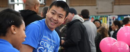 Jay smiling wearing a blue Comcast Cares Day t-shirt at a volunteer event